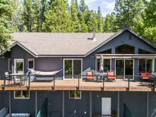 Enjoy the serene mountain lifestyle in this stunning home, featuring a spacious deck perfect for outdoor entertaining and relaxation.