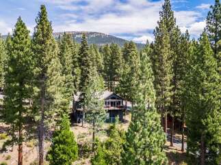 Nestled amidst towering pine trees, this charming home offers a serene mountain retreat.