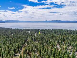 Experience the serene beauty of this lakeside property, nestled amidst a dense forest of towering pine trees.
