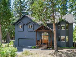 Nestled among tall pine trees, this charming home offers a serene mountain retreat.