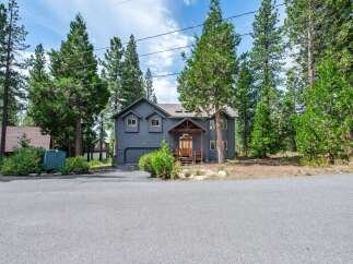 Discover this stunning modern home nestled among tall pine trees, offering a serene and private retreat.