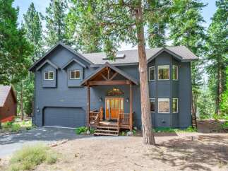 Nestled among tall pine trees, this charming home offers a serene retreat.
