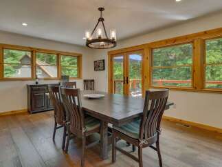 This dining room features a large wooden table surrounded by six chairs, perfect for family gatherings.