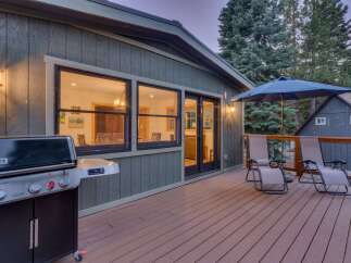 Enjoy outdoor living on this spacious deck, complete with a Weber grill for summer barbecues and comfortable lounge chairs perfect for relaxing under the umbrella.