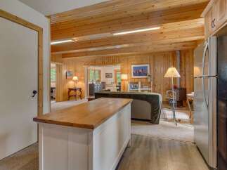 Experience rustic charm in this inviting living space featuring warm wood paneling throughout and a cozy fireplace.