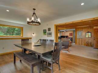 Experience comfortable dining in this spacious room featuring a large wooden table with a bench and chairs, perfect for family gatherings.