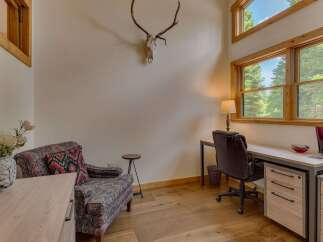 This cozy office space features a comfortable armchair and a functional desk area, perfect for remote work or study.
