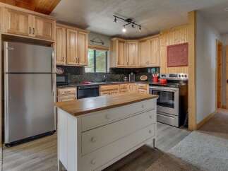 This charming kitchen features light wood cabinetry and a spacious granite countertop, perfect for meal preparation.