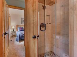Step into a charming cabin retreat featuring a cozy bedroom with a rustic log bed and a stylish plaid comforter.