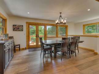 Experience seamless indoor-outdoor living in this charming dining area, featuring a spacious dark wood table and chairs perfect for family gatherings.