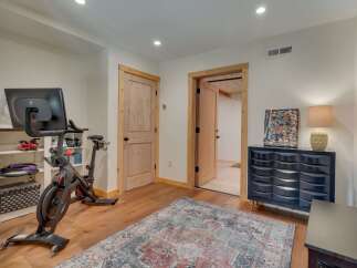 This versatile room offers a dedicated home gym space with a Peloton bike and ample storage, perfect for maintaining your fitness routine.