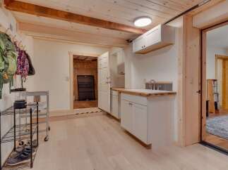 This versatile space offers a practical mudroom area with ample storage for coats and shoes, perfect for outdoor enthusiasts.
