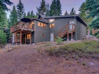 Nestled among tall pine trees, this charming home offers a serene mountain retreat.