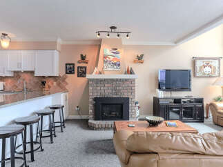 This inviting living space features a cozy brick fireplace, perfect for gathering on chilly evenings.