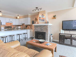 Experience comfortable living in this inviting living room, featuring a cozy brick fireplace and a spacious leather sofa perfect for relaxation.