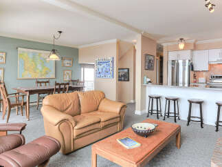 This spacious living area features a comfortable tan leather sofa and a matching recliner, perfect for relaxing.