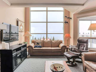 Experience breathtaking mountain views from this stunning living room, featuring a large sectional sofa perfect for cozy evenings.