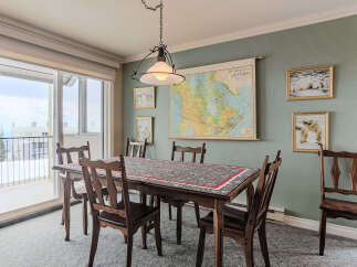 This dining room features a large wooden table with a decorative runner, surrounded by classic wooden chairs.
