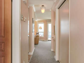 Step into this inviting hallway, leading to a bright living space with large windows offering scenic views.
