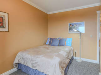 This cozy bedroom features a comfortable bed adorned with plush blue pillows and a stylish quilted comforter.
