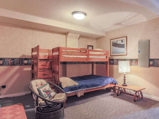 This charming bedroom features a space-saving wooden bunk bed, perfect for accommodating guests or children.