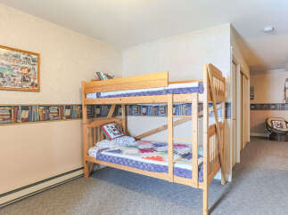 This charming bedroom features a cozy wooden bunk bed, perfect for accommodating guests or children.