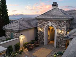 Experience luxury living in this stunning home featuring a grand stone-accented entryway with an arched opening, perfect for welcoming guests.