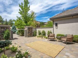 This inviting outdoor patio features a natural fiber rug and comfortable seating, perfect for enjoying the serene surroundings.