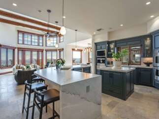 Experience luxury living in this stunning open-concept kitchen and living area, boasting breathtaking panoramic views through expansive windows.