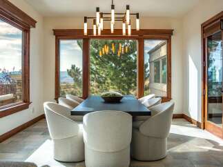 Experience breathtaking views from this elegant dining room, featuring a large table surrounded by plush chairs.