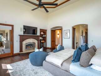 Experience luxury and comfort in this master suite, featuring a cozy fireplace and a mounted television for ultimate relaxation.