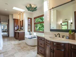 Indulge in luxury with this stunning master bathroom, featuring a freestanding soaking tub perfect for relaxation.