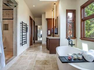 Experience luxury in this stunning bathroom featuring a freestanding soaking tub and a spacious walk-in shower with elegant tilework.