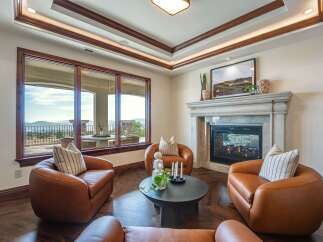 Experience luxury living in this stunning room featuring plush leather armchairs arranged around a modern coffee table.