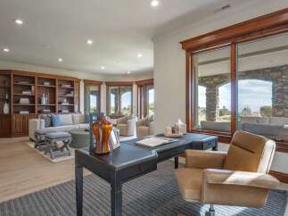 This spacious living area features a large built-in bookshelf, a comfortable sectional sofa, and a cozy seating area with armchairs.