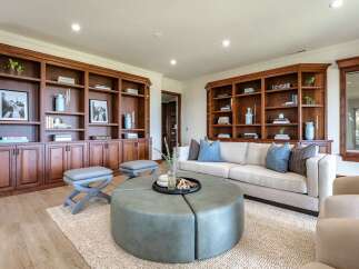 This living room boasts custom built-in wooden bookshelves, offering ample storage and display space for decor and literature.