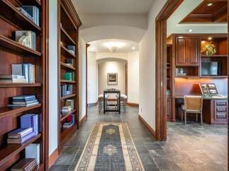 Step into this elegant home featuring a dedicated library with rich mahogany bookshelves, perfect for the avid reader.