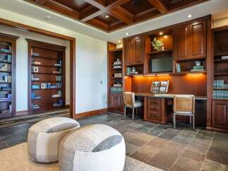 Step into this elegant home office, featuring rich mahogany built-in bookshelves and cabinetry that exude timeless sophistication.