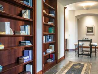 This elegant hallway features built-in cherry wood bookshelves filled with a curated collection of books, offering a sophisticated and intellectual ambiance.