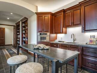 This spacious kitchen features rich cherry wood cabinetry and a large island perfect for meal preparation and casual dining.