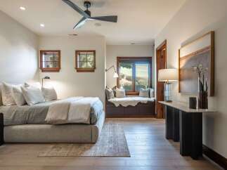 Experience serene living in this beautifully appointed bedroom, featuring a plush king-sized bed and a cozy window seat with stunning natural views.