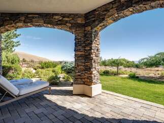 Enjoy breathtaking views from this covered patio, featuring a comfortable chaise lounge perfect for relaxation.