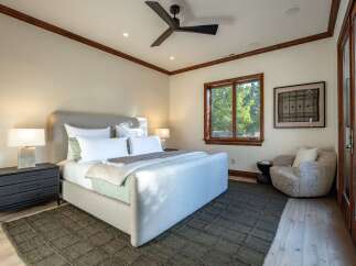 Experience ultimate comfort in this beautifully appointed bedroom, featuring a plush upholstered bed and a cozy reading nook.