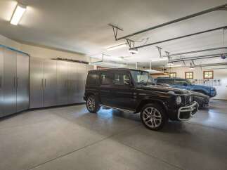 This spacious garage offers ample storage with sleek, modern cabinetry lining the walls.