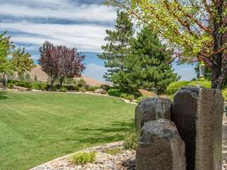 Experience the tranquility of this beautifully landscaped property, featuring a lush green lawn perfect for outdoor activities.