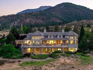 Experience luxury living in this stunning estate nestled against a majestic mountain backdrop.