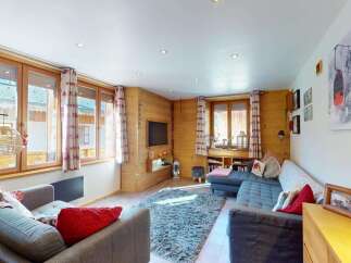Experience cozy living in this charming mountain retreat, featuring warm wood paneling and large windows that flood the space with natural light.
