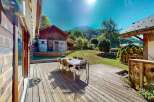 Enjoy outdoor living on this expansive wooden deck, perfect for al fresco dining with a table and chairs set.