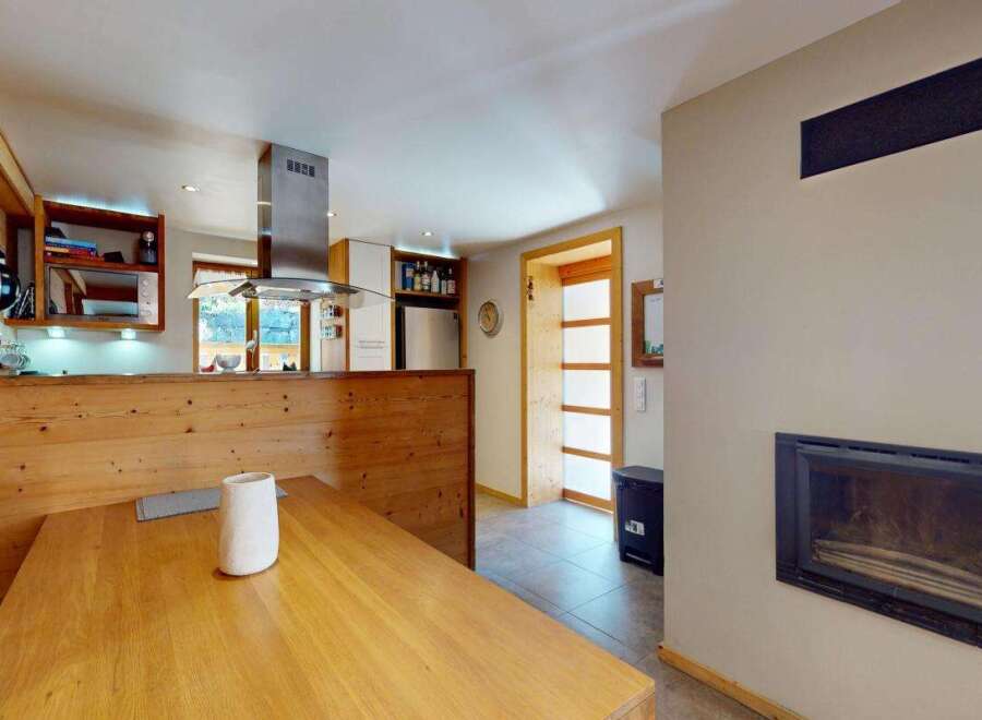 Experience cozy living in this charming kitchen and dining area, featuring a rustic wooden booth seat and a spacious dining table perfect for family meals.