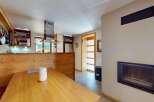Experience cozy living in this charming kitchen and dining area, featuring a rustic wooden booth seat and a spacious dining table perfect for family meals.